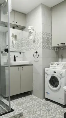 a bathroom with a washing machine and a sink at Apartments Srbija Waterfront - FREE PARKING in Belgrade