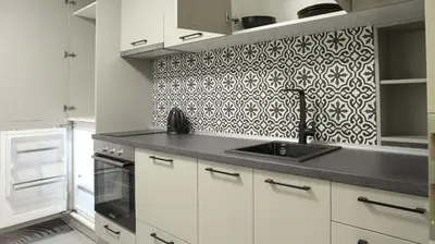 a kitchen with white cabinets and a black and white wallpaper at Apartments Srbija Waterfront - FREE PARKING in Belgrade