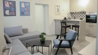 a living room with a couch and a kitchen at Apartments Srbija Waterfront - FREE PARKING in Belgrade