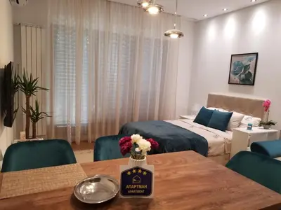 a room with two beds and a table with flowers on it at Azura Residence - new luxury apartment in Belgrade
