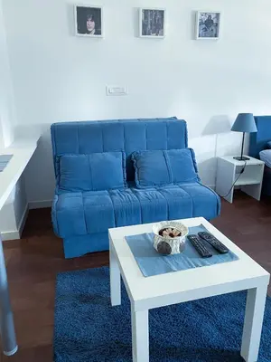 a living room with a blue couch and a table at Apartment Azzurro lux in Novi Beograd
