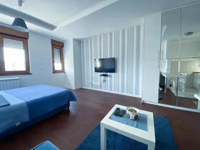 a bedroom with a blue bed and a table at Apartment Azzurro lux in Novi Beograd