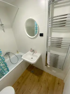 a white bathroom with a sink and a shower at Apartment Azzurro lux in Novi Beograd