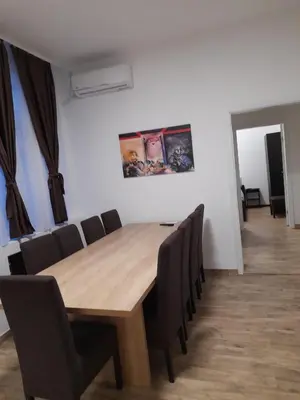 a dining room with a wooden table and chairs at BUDGET Apartment Artistika, 3 Bedrooms and 2 full Bathrooms in Belgrade