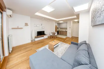 a living room with a blue couch and a table at Apartment N2 - A Blok in Belgrade