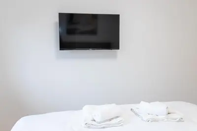 a bed with towels on it with a tv at Apartment N2 - A Blok in Belgrade