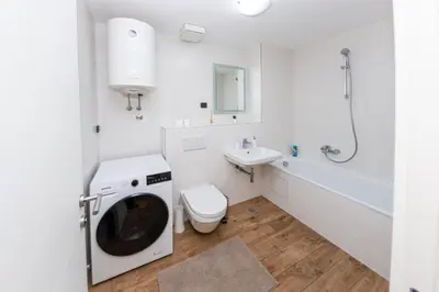 a white bathroom with a washing machine and a toilet at Apartment N2 - A Blok in Belgrade