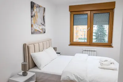a bedroom with a white bed and a window at Apartment N2 - A Blok in Belgrade