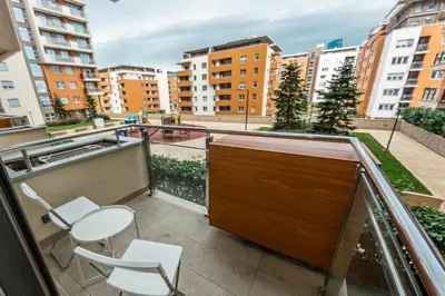 a balcony with a table and chairs and buildings at Apartment N2 - A Blok in Belgrade