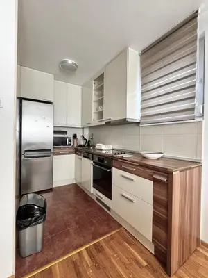 a kitchen with white cabinets and stainless steel appliances at Zemunske kapije 2 Prizrenska in Novi Grad