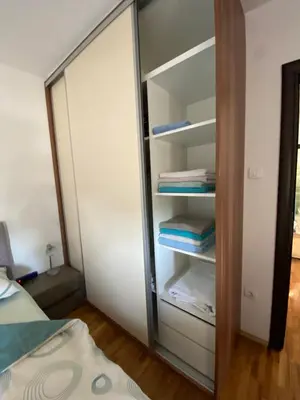 a closet with a glass door next to a bed at Zemunske kapije 2 Prizrenska in Novi Grad