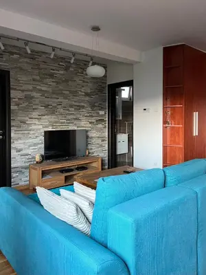 a blue couch in a living room with a tv at Zemunske kapije 2 Prizrenska in Novi Grad
