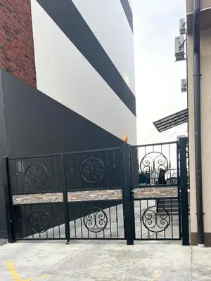 a black fence with two benches in front of a building at Zemunske kapije 2 Prizrenska in Novi Grad