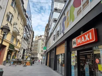 a city street with many buildings and a sign for a maxiq store at BUDGET Guest Room in Central Pedestrian Zone in Belgrade