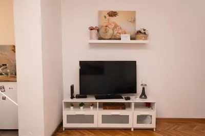 a living room with a tv on a white entertainment center at apartman Fuerte 2 in Belgrade