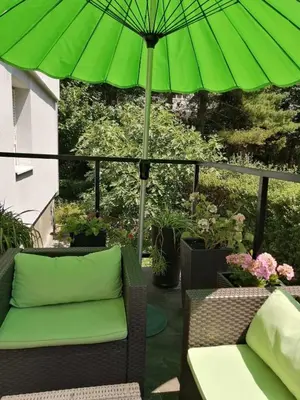 a green umbrella sitting on top of a patio at apartman Fuerte 2 in Belgrade