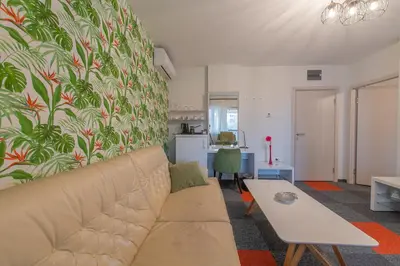 a living room with a couch and a kitchen at Apartmani Maximilian in Čukarica
