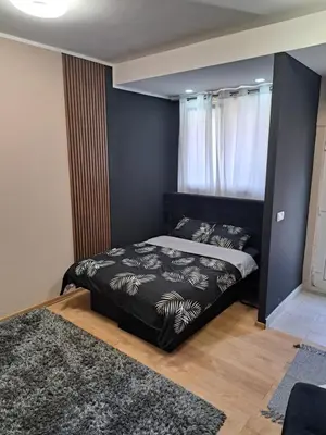 a bedroom with a bed with a black headboard at Dvoriste Danguba in Nova Pazova