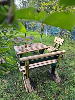a wooden picnic table sitting in the grass at Dvoriste Danguba in Nova Pazova