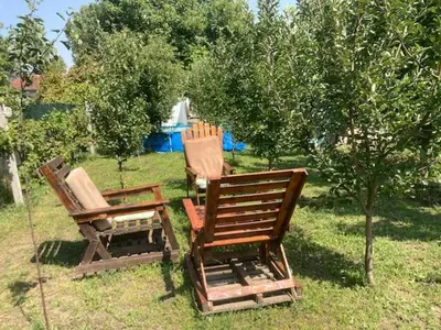 two chairs and a table sitting in the grass at Dvoriste Danguba in Nova Pazova