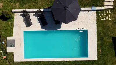 an overhead view of a swimming pool and an umbrella at Family House in Krčedin