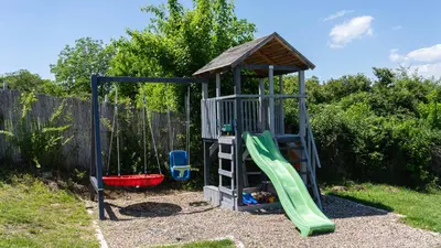 a playground with a slide and a swing at Family House in Krčedin