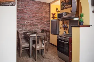 a small kitchen with a table and a brick wall at BOTANIK in Belgrade