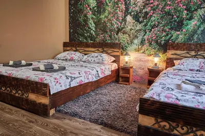 two beds in a room with a painting on the wall at BOTANIK in Belgrade