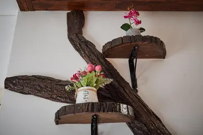 a cross made out of logs with a vase with flowers at BOTANIK in Belgrade