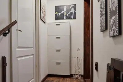 a white dresser in a hallway with a picture on the wall at BOTANIK in Belgrade