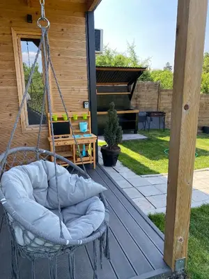 a swing on the deck of a house with a piano at Woody House in Krčedin