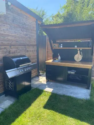 a grill in a yard next to a fence at Woody House in Krčedin