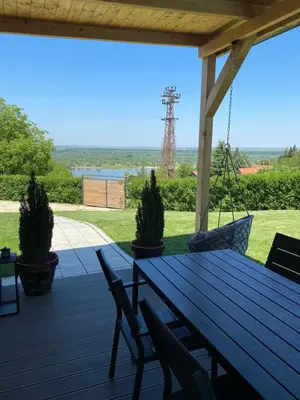 a wooden table and chairs on a deck with a view of the ocean at Woody House in Krčedin