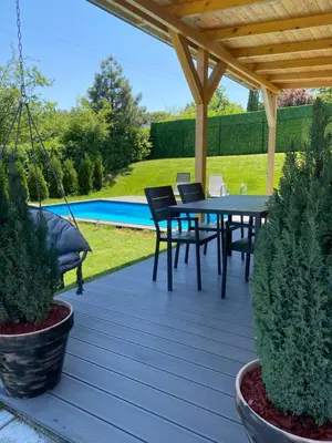 a patio with a table and chairs under a pergola at Woody House in Krčedin