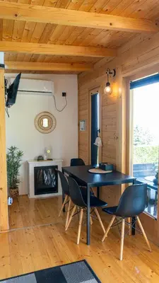 a dining room with a black table and chairs at Woody House in Krčedin
