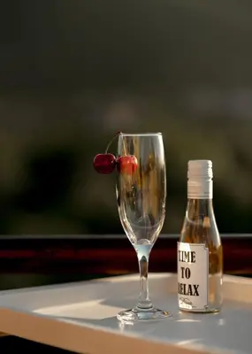 a wine glass and a bottle on a table at Diva apartman in Arandjelovac
