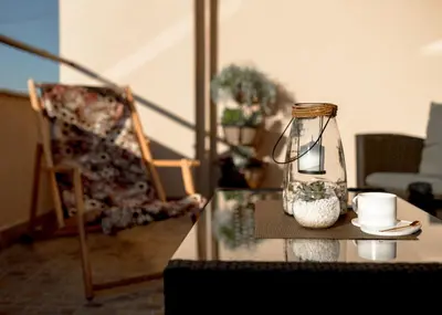 a table with a lamp and a chair in a living room at Diva apartman in Arandjelovac