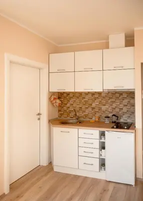 a kitchen with white cabinets and a sink at Diva apartman in Arandjelovac