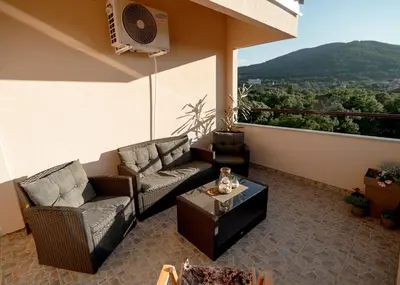 a patio with two couches and a table on a balcony at Diva apartman in Arandjelovac
