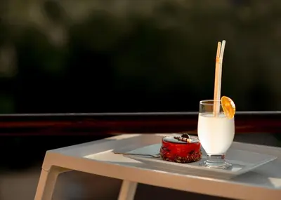 a plate with a drink and a piece of food on a table at Diva apartman in Arandjelovac