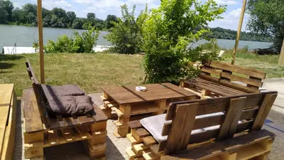 a wooden picnic table and chairs with a view of a lake at Top Chill party kucice apartmani in Belgrade