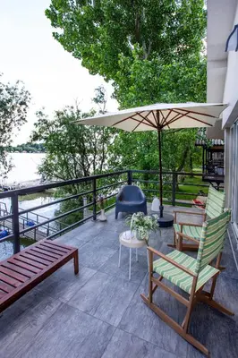 a patio with two chairs and an umbrella at River house Grana in Belgrade
