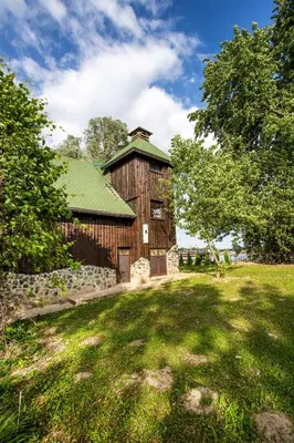 a wooden barn with a green roof in a field at River house Vasa in Belgrade