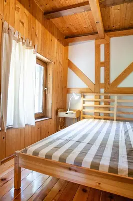a bedroom with a bed in a wooden room at River house Vasa in Belgrade