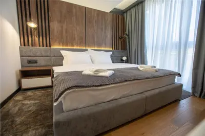 a bedroom with a bed with two towels on it at Hotel Borneo in Pančevo