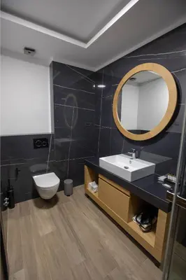 a bathroom with a sink and a toilet and a mirror at Hotel Borneo in Pančevo