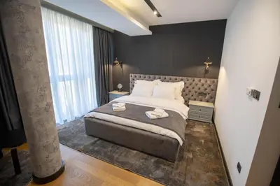 a bedroom with a large bed and a large window at Hotel Borneo in Pančevo