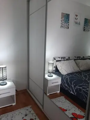 a mirror in a bedroom with a bed and two night stands at Tanja 3 in Dušanovac (historical)