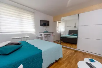 a bedroom with a blue bed and a mirror at Apartment SELF CHECK IN 00-24 MM in Belgrade