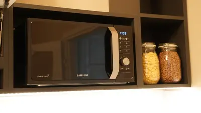 a microwave on a shelf with two jars of food at Yes Apartment, Belgrade Center in Belgrade